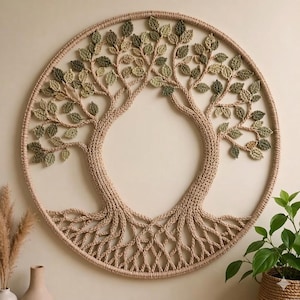 Könnte beinhalten: Ein kreisförmiger Wandbehang mit einem gehäkelten Baummotiv aus beigem Garn. Der Baum hat einen dicken Stamm und Äste, die bis zum äußeren Ring reichen und mit zahlreichen kleinen, einzelnen Blättern aus verschiedenfarbigem grünen Garn verziert sind.