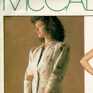 May include: A vintage McCall's sewing pattern, number 2377, featuring a Laura Ashley design. The pattern includes illustrations of a jacket and dress ensemble, and a top and skirt. The pattern is for a Miss Size 8.