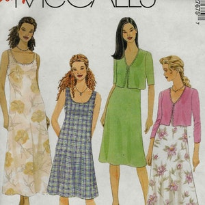 May include: McCall's sewing pattern featuring four dress designs. The dresses include a floral print maxi dress, a plaid dress, a solid green dress with a matching jacket, and a floral print skirt with a pink cardigan. The pattern size is E (14-16-18).