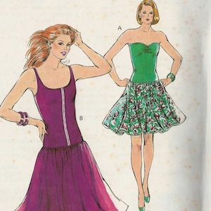 May include: Two women's dresses, one is a strapless green dress with a floral print skirt and the other is a purple dress with a fitted bodice and a flowing skirt. The dresses are labelled A and B.