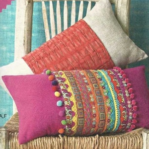 May include: Simplicity pattern 1440 OS featuring five pillow designs. The pillows are displayed on chairs, showcasing various styles, including a red pillow with triangles, a pink pillow with colorful trim, and a green pillow with white circles.