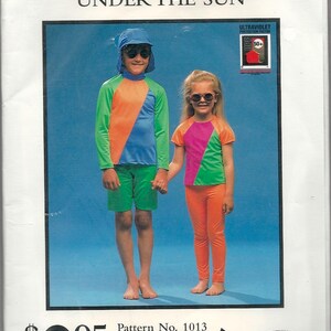 May include: A vintage sunsuit pattern advertisement featuring two children wearing colorful sunsuits and sunglasses. The text reads "THE BEST SUNSUIT PATTERN UNDER THE SUN" and includes a price of $2.95. The pattern is for sizes 2-6.
