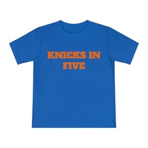 Op de afbeelding: Een koningsblauw T-shirt met korte mouwen en de tekst KNICKS IN FIVE in dikke oranje blokletters op het midden van de borst. Het kledingstuk heeft een klassieke ronde hals en een standaard pasvorm met korte mouwen.