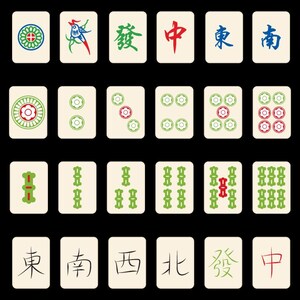 Op de afbeelding: Een verzameling ivoorkleurige Mahjong-tegels met diverse symbolen en karakters in rood, groen en blauw. De tegels tonen bloemmotieven, Chinese karakters en numerieke representaties, tegen een zwarte achtergrond.