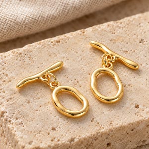 Gold-tone brass oval toggle clasps. Macro detail. ring 20 x 12.5mm; T-bar 23.8mm. Buyer pack: 4 complete clasp sets.