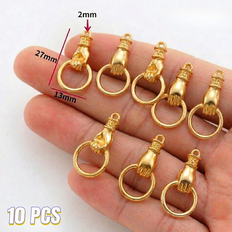 May include: Ten gold-colored hand-shaped charms with a ring. Each charm is approximately 1 inch long, 0.5 inches wide, and 0.08 inches thick. The charms are designed to be used for jewelry making or crafting.