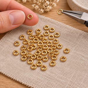 Gold-tone stainless steel closed jump rings. Example of handling the component; tools are not included. 4mm outer diameter; 1.2mm wire. Buyer pack: 50 pieces.