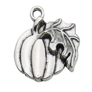 May include: A silver-toned metal charm shaped like a pumpkin with a single leaf attached to the side. The charm features a circular jump ring at the top for attachment, with raised ridges on the pumpkin and detailed veins on the leaf surface.
