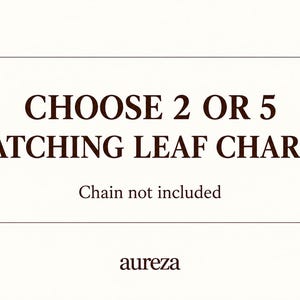 May include: A white rectangular sign with dark brown text that reads CHOOSE 2 OR 5 MATCHING LEAF CHARMS, followed by the text Chain not included, and the brand name aureza at the bottom, framed by two horizontal lines above and below the main text.