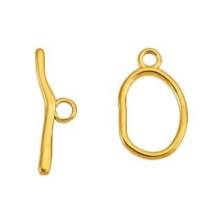 Original supplier Gold-G sample set: elongated oval ring and long curved T-bar.