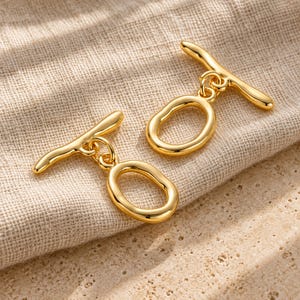 Gold-tone brass oval toggle clasps. Textured hero view. ring 20 x 12.5mm; T-bar 23.8mm. Buyer pack: 4 complete clasp sets.