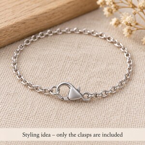 Silver stainless steel lobster clasps. Styling idea; finished jewellery is not included. 6 x 12mm. Buyer pack: 10 pieces.