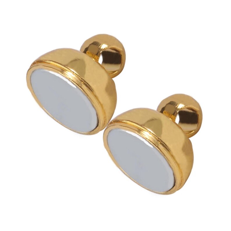 Two authentic matching gold-tone magnetic halves separated to show their flat circular contact faces.