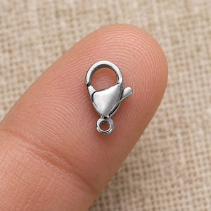 Silver stainless steel lobster clasps. Scale reference preview. 6 x 12mm. Buyer pack: 10 pieces.