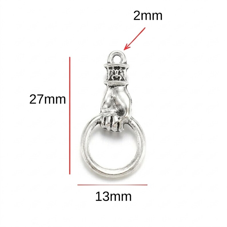 May include: A silver-toned metal charm shaped like a hand holding a circular ring. The charm features a loop at the top for attachment. Dimensions are indicated by red lines as 27mm in total height, 13mm in width, and a 2mm loop diameter.