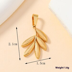 May include: A gold-colored metal pendant shaped like a small branch with five leaves. The pendant features a top bail for attachment. Dimensions are indicated as 2.1 cm in height and 1.5 cm in width, with a total weight of 1.6 grams.