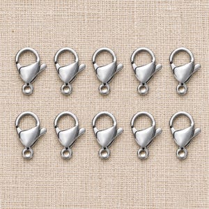 Silver stainless steel lobster clasps. Pack flat lay; quantity check pending. 6 x 12mm. Buyer pack: 10 pieces.