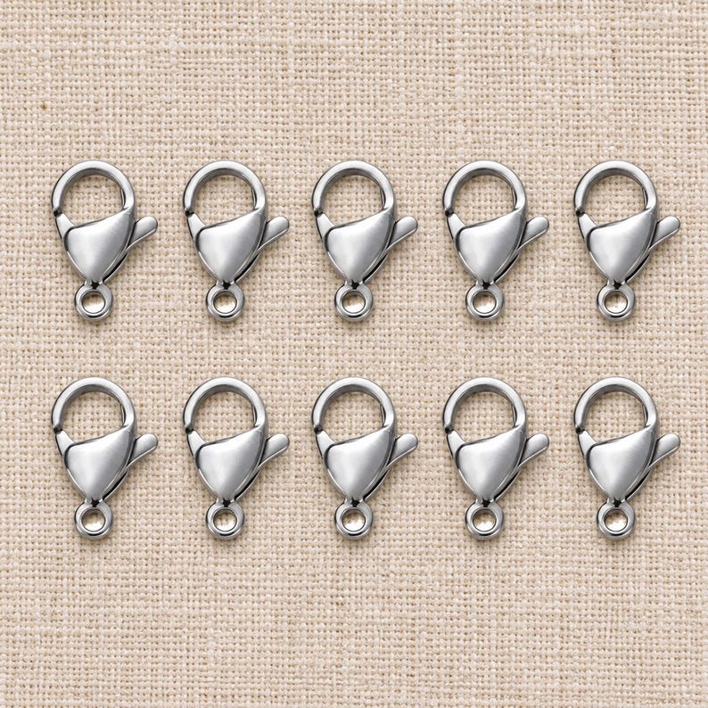 Silver stainless steel lobster clasps. Pack flat lay; quantity check pending. 6 x 12mm. Buyer pack: 10 pieces.