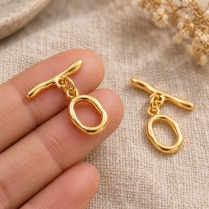 Gold-tone brass oval toggle clasps. Scale reference preview. ring 20 x 12.5mm; T-bar 23.8mm. Buyer pack: 4 complete clasp sets.