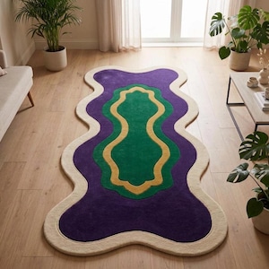May include: An area rug with an irregular, wavy-edged shape featuring concentric layers of color. The design consists of a central dark green section, a mustard yellow border, a larger purple layer, and an outer cream-colored trim.