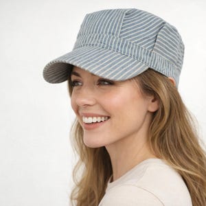 May include: A blue and white striped cap with a short brim. The cap has a structured design and a flat top. The fabric has a denim-like appearance. The cap is a casual accessory.