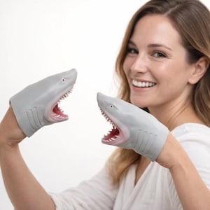 May include: Gray shark hand puppets with open mouths and visible teeth. The puppets are designed to fit over the hands, creating a playful and interactive toy. The shark puppets have a realistic design with gray skin and red mouths.