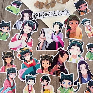 May include: A selection of anime-style stickers depicting characters in traditional Asian clothing. The stickers display diverse characters with detailed facial expressions and vibrant outfits, set on a wooden surface. Some stickers include the Japanese text "薬屋のひとりごと".