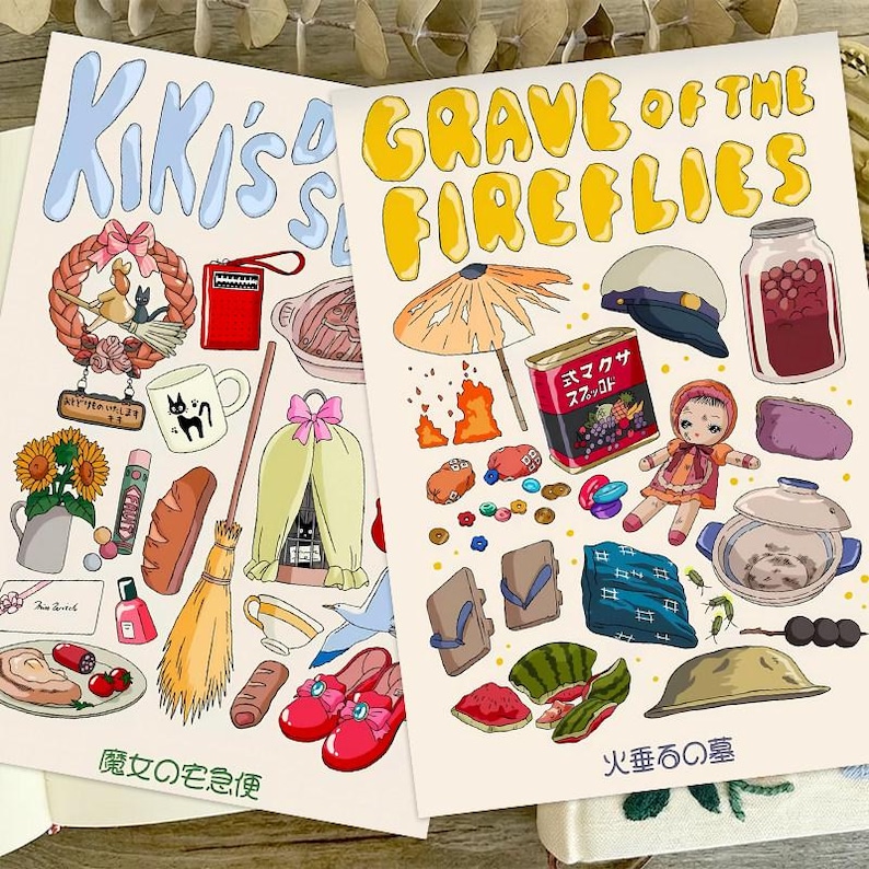 Peut inclure: Deux impressions d'art illustr&eacute;es avec des dessins color&eacute;s d'objets et de texte. L'une des impressions dit "Kiki's Delivery Service" et l'autre dit "Grave of the Fireflies" en lettres jaunes. Les impressions pr&eacute;sentent une vari&eacute;t&eacute; d'objets et d'illustrations.