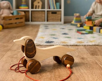 Juguete de madera para tirar con forma de perro salchicha.