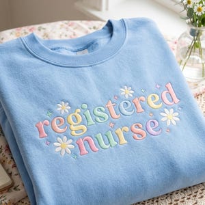 刺繍入り登録看護師スウェットシャツ、デイジーRN Tシャツ、パステルカラーの看護師アパレル