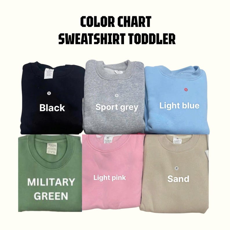 May include: Color chart of toddler sweatshirts in various colors. The sweatshirts are black, sport grey, light blue, military green, light pink, and sand. Each sweatshirt has a small white tag.