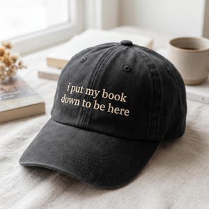 "Bestickter ""I Put My Book Down To Be Here"" Hut - Geschenk für Buchliebhaber."
