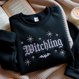 刺繍入りウィッチリング・マノン・ブラックビーク・スウェットシャツ、スローン・オブ・グラス・グッズ、ブックトック・リーダーTOGアパレル