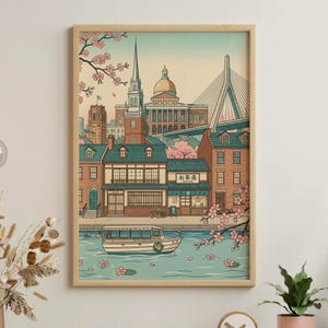 May include: Framed art print featuring a stylized illustration of a cityscape with a bridge, buildings, and a boat on the water. Cherry blossoms in pink and white frame the scene. The print has a light wood frame.