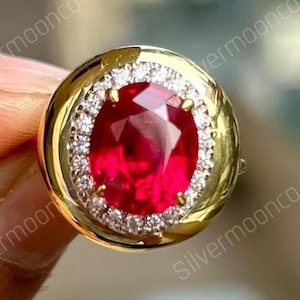 Ring met ovaal geslepen roze robijn (9 x 7 mm), geboortesteen van juli, met een halo in de vorm van een snoepknop en een robuuste zetting, gemaakt van 925 zilver.