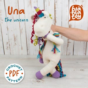 May include: A crocheted unicorn toy in cream, with a rainbow mane, tail, and horn. The unicorn has purple hooves and a colorful scarf. The image includes the text "Una the unicorn" and a "Crochet PDF Pattern" logo.