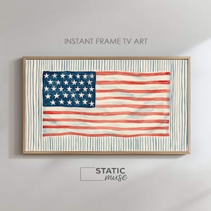 May include: A rectangular digital television art display featuring a watercolor-style American flag with red stripes and a blue canton with white stars. The flag is centered against a background of vertical blue pinstripes in a wooden frame.
