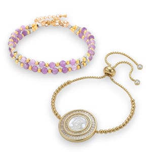May include: Two bracelets. One is a double-strand design with purple beads, gold, and silver accents. The other is a gold-toned adjustable bracelet with a round pendant featuring a white mother-of-pearl design and clear baguette-cut stones.