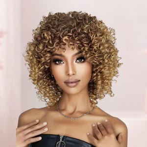 May include: A woman with a curly, shoulder-length wig in shades of brown and blonde. The wig has a natural-looking texture and volume. The woman is wearing a black top and a silver necklace. The background is a soft pink.