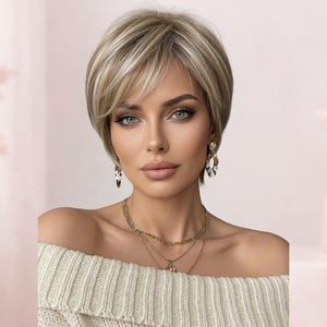 May include: A short, layered blonde wig with dark roots and side-swept bangs. The hair features a mix of light blonde and ash tones, styled in a smooth, rounded cut. The wig is worn with gold-toned layered necklaces and patterned drop earrings.