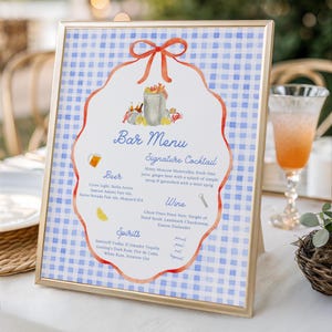 Könnte beinhalten: Ein goldgerahmtes Bar-Menü-Schild mit blau-weißem Vichy-Karo-Hintergrund. In der Mitte befindet sich eine weiße, gewellte Form mit einer orangefarbenen Schleifengrafik, die Cocktails, Bier, Wein und Spirituosen mit Aquarellillustrationen auflistet.