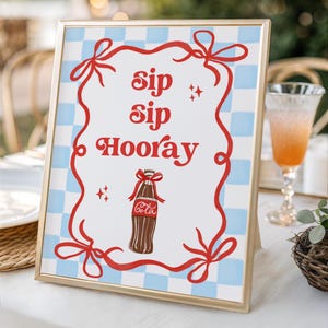 Peut inclure: Une enseigne rectangulaire à cadre doré avec un fond à carreaux bleu clair et blanc. Le centre affiche le texte rouge 'sip sip Hooray' au-dessus d'une illustration de bouteille en verre marron avec un ruban rouge et le mot 'Cola' en blanc.