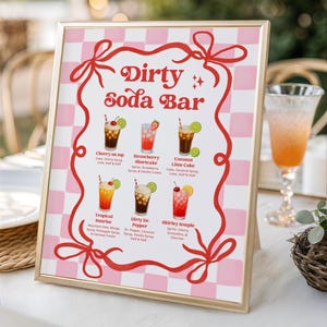 Könnte beinhalten: Ein goldgerahmtes Schild mit rosa-weiß kariertem Hintergrund und rotem Schleifenrand. Der Text lautet Dirty Soda Bar und listet sechs Getränkerezepte auf: Cherry on top, Strawberry Shortcake, Coconut Lime Coke, Tropical Sunrise, Dirty Dr. Pepper und Shirley temple mit ihren Zutaten.