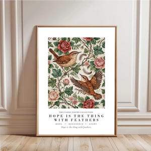 Puede incluir: Una impresión artística vertical enmarcada que muestra dos pájaros marrones posados entre hojas verdes y rosas rosadas. Debajo de la ilustración, el texto dice: THE CLASSIC POETRY COLLECTION, HOPE IS THE THING WITH FEATHERS, HOPE • RESILIENCE • LIGHT, Hope is the thing with feathers.