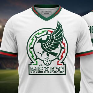 Pu&ograve; includere: Una maglia da calcio bianca con un emblema di un'aquila verde sopra la scritta M&Eacute;XICO sul davanti. Le maniche e il colletto a V presentano bordi verdi e rossi. Sul retro sono riportati il nome HERN&Aacute;NDEZ e il numero 10 in verde scuro.