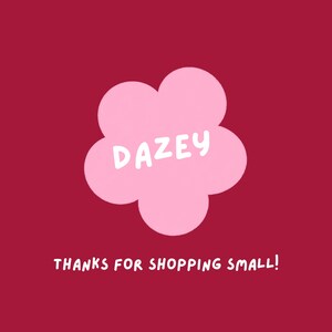 May include: A pink flower-shaped graphic with the word "DAZEY" in white text, set against a deep red background. Below the flower, the phrase "THANKS FOR SHOPPING SMALL!" is written in white.