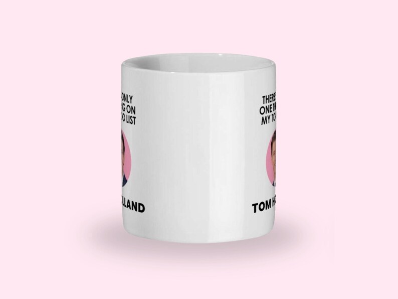 May include: White ceramic mug with the text "There's only one thing on my to-do list" and "Tom Holland". The mug features a pink circle with a picture of Tom Holland.