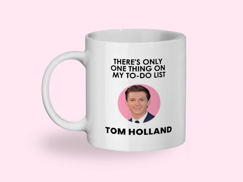May include: White ceramic mug with the text "THERE'S ONLY ONE THING ON MY TO-DO LIST" and the name "TOM HOLLAND" below a photo of Tom Holland in a pink circle.