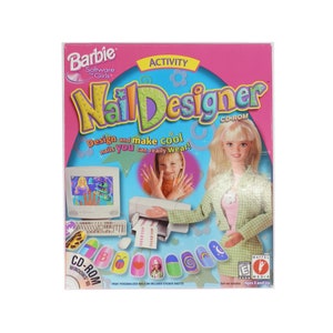 Pode incluir: Uma caixa rosa e verde para um jogo de computador Barbie Software Girls chamado "Nail Designer". A caixa apresenta uma imagem de uma boneca Barbie com um vestido xadrez verde e branco e uma flor rosa em sua camisa. O jogo é para crianças de 5 anos ou mais.