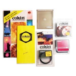 May include: A selection of Cokin Creative Filter System products, including a guide, filters, and packaging. The guide is yellow and features the Cokin logo. Various filters are visible, some in clear plastic cases.
